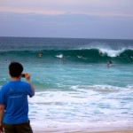 boy photographs surfers at Pipeline